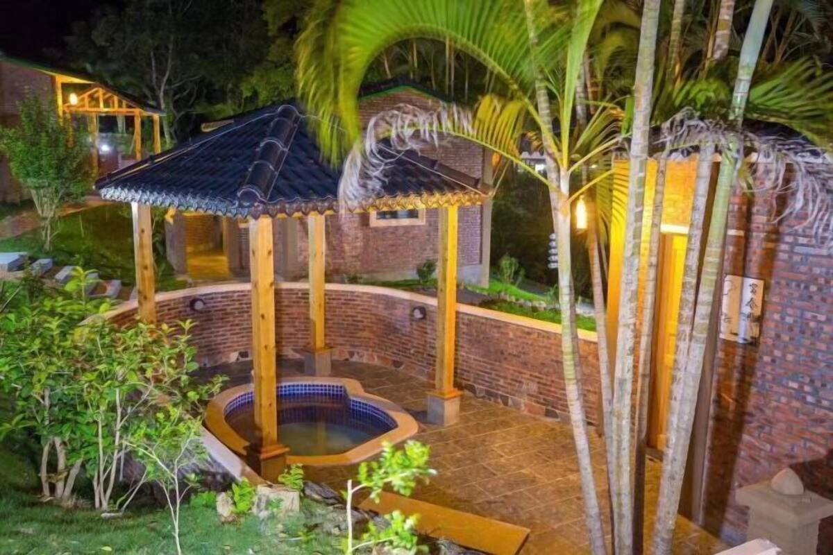 Un edificio de ladrillo con piscina de baldosas y estructuras de madera.