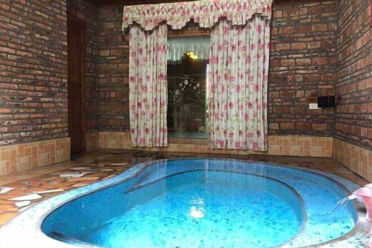 Una piscina interior pequeña con suelo de baldosas y paredes de ladrillo.