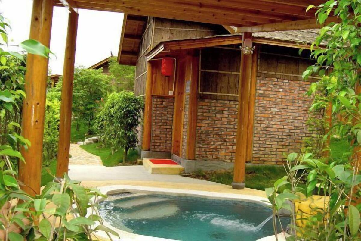 Una estructura de madera con fachada de ladrillo, un jacuzzi y un camino que conduce a él.