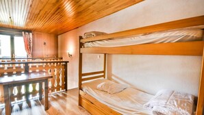 A bunk bed room with wooden flooring and a wooden ceiling.