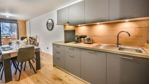 Et moderne køkken med grå skabe, en træbordplade og en indbygget vask.