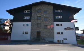 Um edifício de dois andares com fachada de pedra e uma placa com a inscrição 'Le Clos Fleuri'.