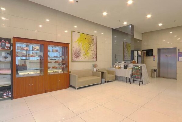 A reception area with a sofa, a table with a chalkboard, and a display cabinet. - Jinjiang Inn (Yixing Renmin Middle Road Pedestrian Street) (Yixing)