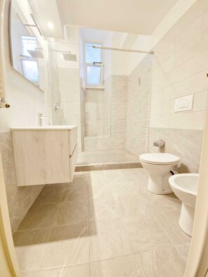 Een douche, een haardroger, een bidet, handdoeken