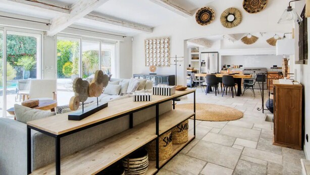 A spacious living area with a large window, a wooden coffee table, and a sofa.