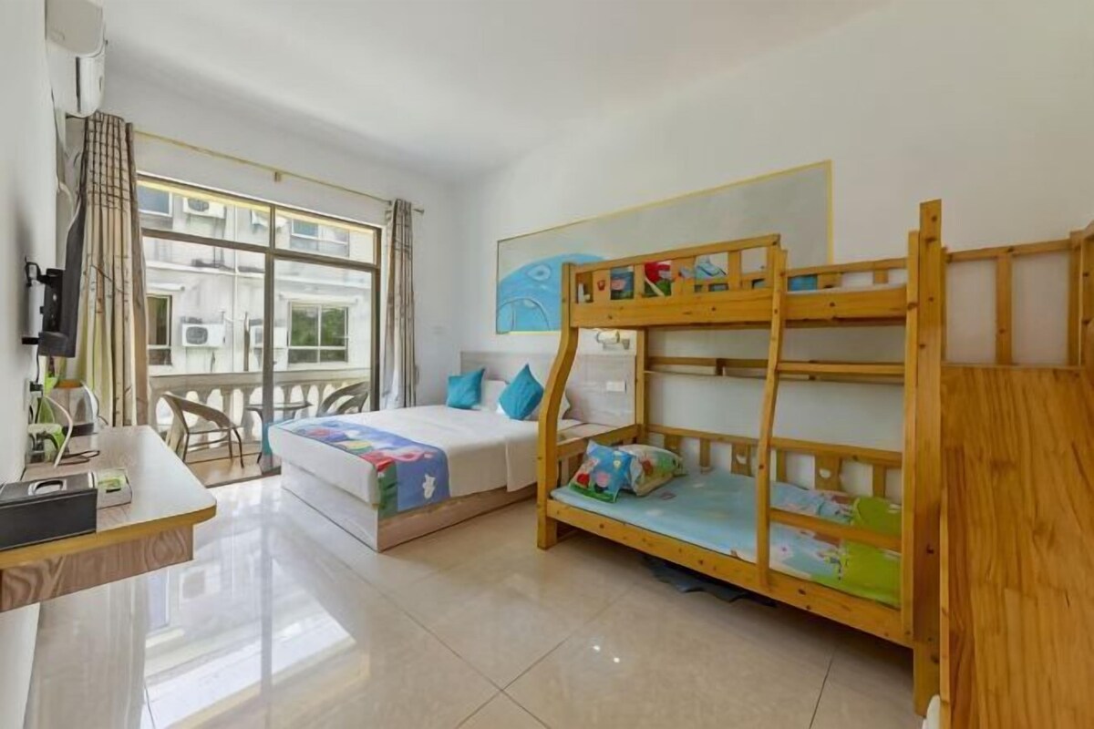 Um quarto com beliches, uma escrivaninha e uma janela com cortinas.