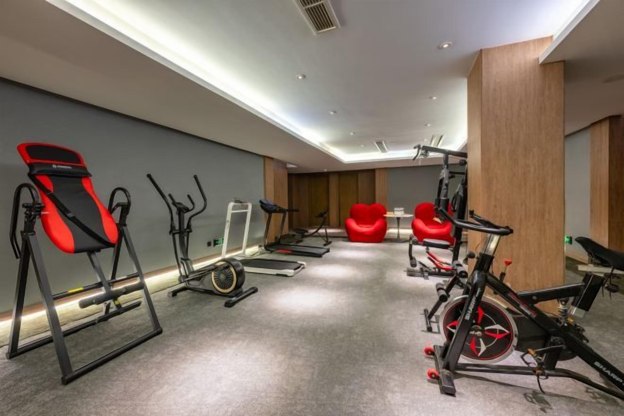 A gym with exercise equipment including treadmills, stationary bikes, and a rowing machine.