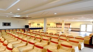 A conference room with rows of chairs, a stage, and a buffet area. - Ethnic India Tourist Resort (Sonepat)