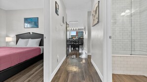 A modern hotel room with a bed, a dining area, and a shower. - 1214 Lambeau Field Luxe (Green Bay)