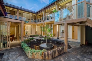 A multi-level courtyard with a central water feature, outdoor seating, and a view of the sky. - Lijiang Shechen Inn (Lijiang)