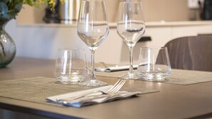 A dining table with four wine glasses and a vase of flowers. - STANDARD DOUBLE  BED APARTMENT  (Banyoles)
