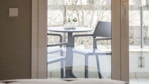 A bedroom with a large window, a bed, and a small table with a plant. - STANDARD DOUBLE  BED APARTMENT  (Banyoles)