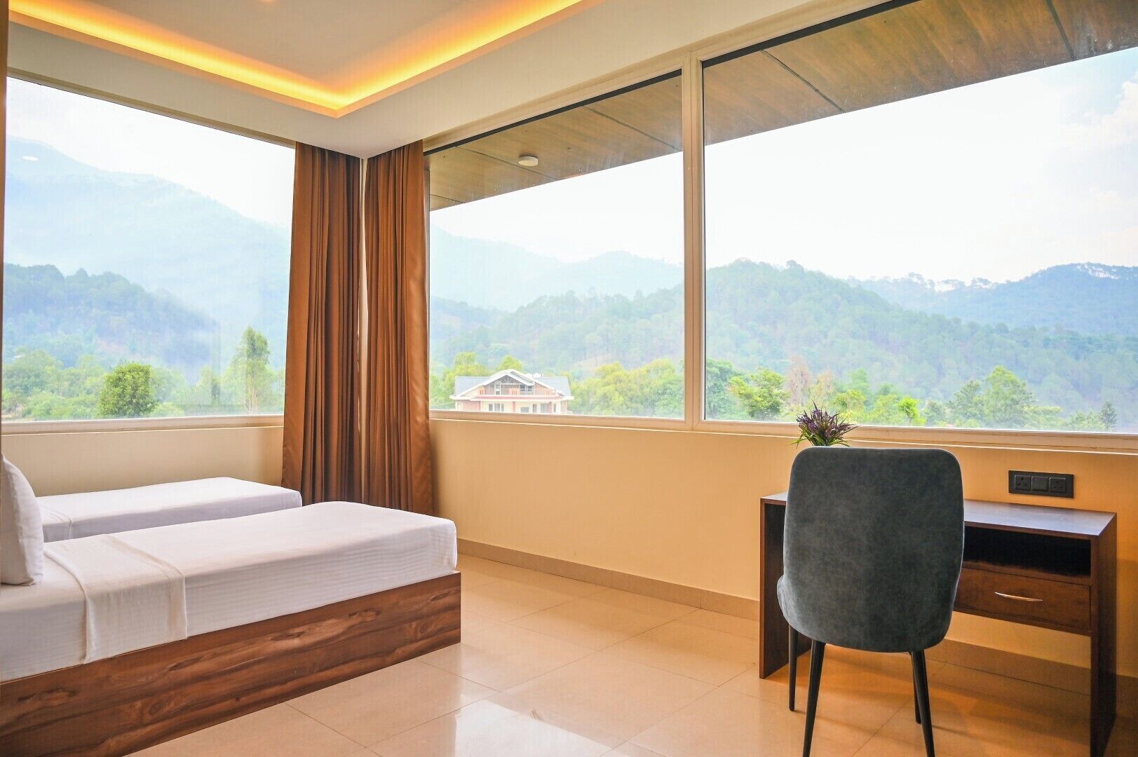 Une chambre avec un lit, un bureau et une vue sur les montagnes.