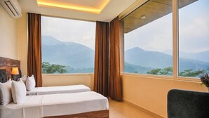 A hotel room with two beds, a view of mountains, and a large window. - Aotel by Clarks Inn Palampur (Palampur)
