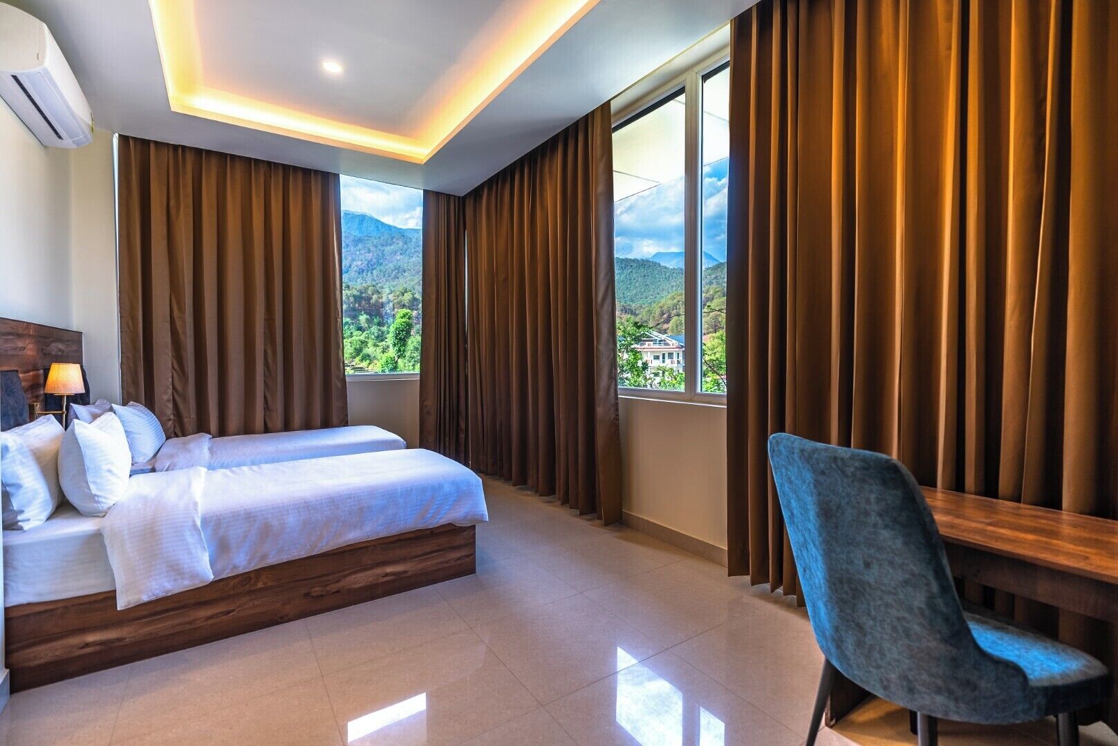 Une chambre d’hôtel avec un lit, un bureau et une vue sur les montagnes.