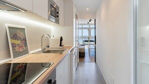 Una cocina moderna con microondas integrado, cafetera y lavamanos.