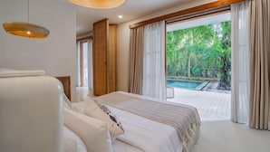 A bedroom with a large bed, a hanging light fixture, and a view of a swimming pool. - White Goose Boutique Hotel (Bali)