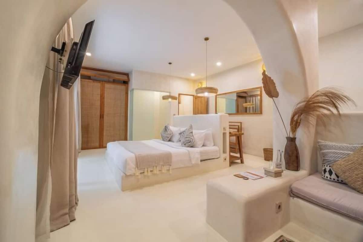 A modern bedroom with a bed, bedside table, and a mirror.