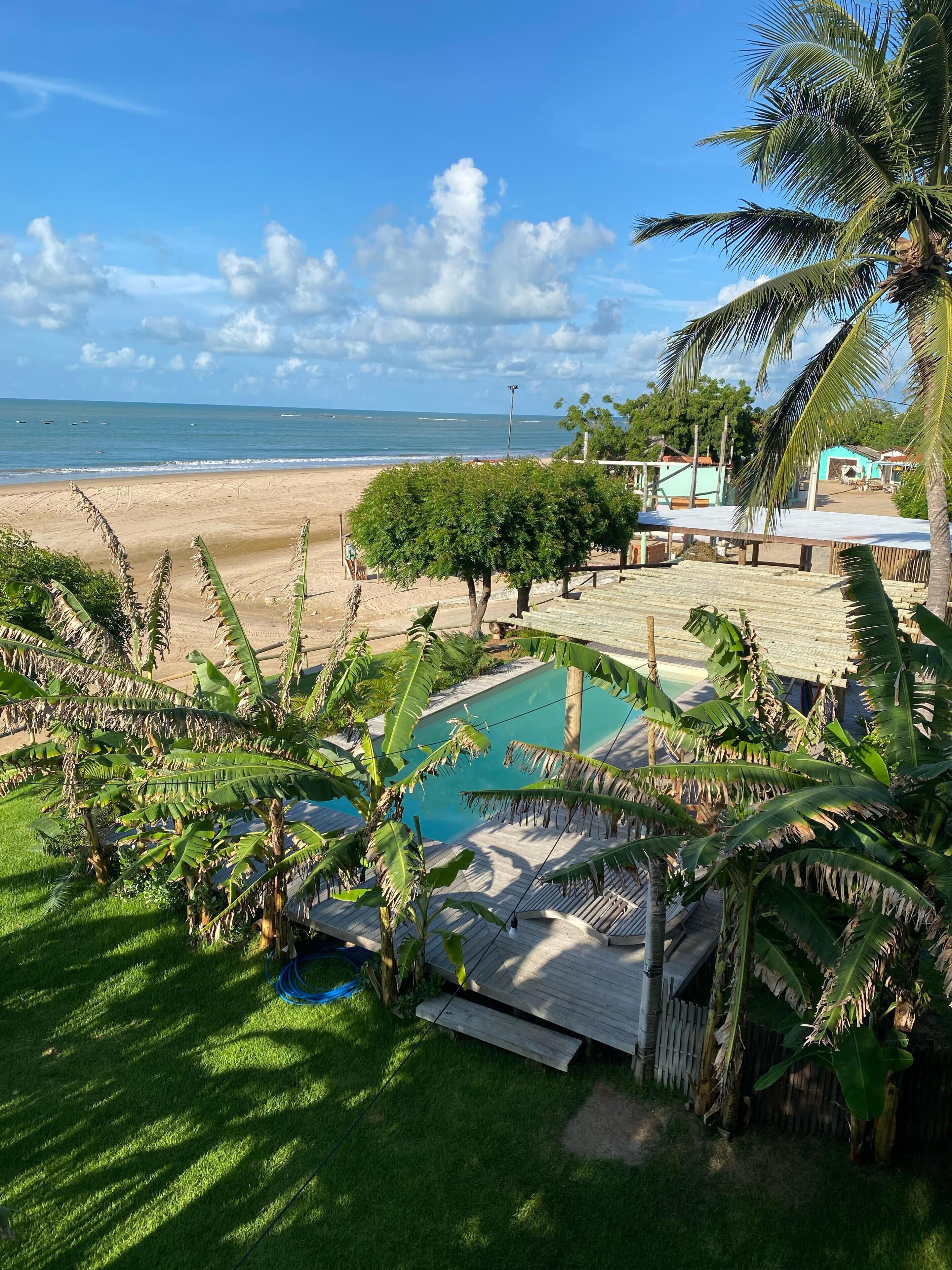 A pool area with a view of the beach and ocean.