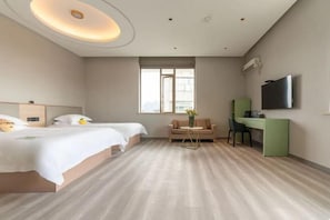 Hotellihuone, jossa on kaksi sänkyä, työpöytä, televisio ja ikkuna.