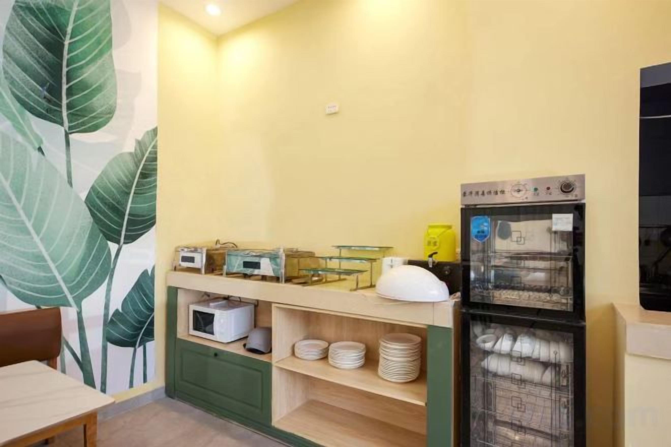 Una cocina con refrigerador, microondas y cafetera en la encimera.