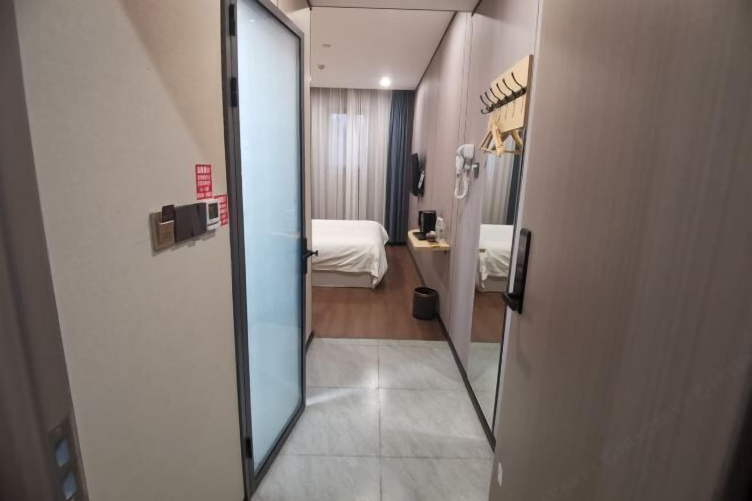 Une chambre d’hôtel équipée d’un lit, d’un bureau, d’un téléphone et d’un miroir.