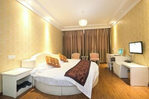 Una habitación de hotel con cama, escritorio, silla y televisión.