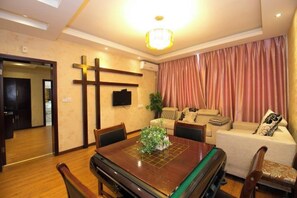 Un comedor con una mesa de madera, sillas y una cruz en la pared.
