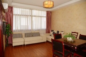 Una habitación con sofá, mesa de comedor, sillas y cortinas.
