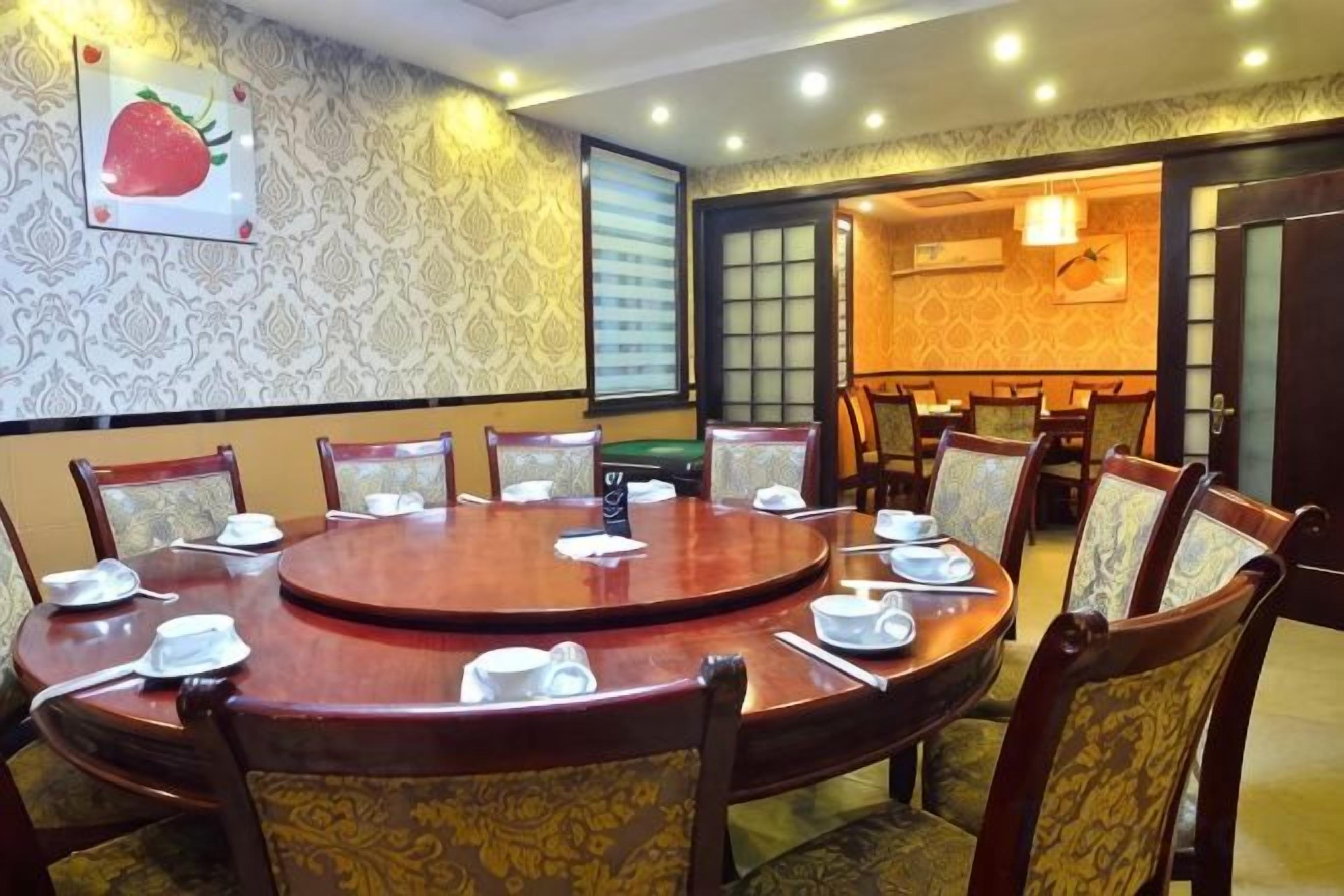 A conference room with a round table, chairs, and a large window.