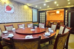 Un salón de conferencias con una mesa redonda, sillas y un amplio ventanal.
