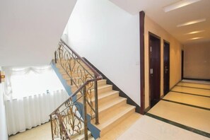 A staircase with a metal railing leading to a landing.