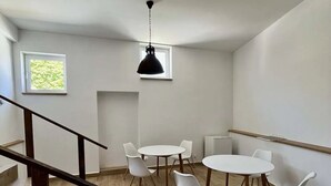 A modern interior with a staircase, white walls, and a ceiling fan. - Chateau Kravín (Kurimany)