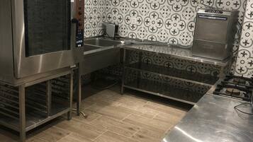 Uma cozinha moderna com eletrodomésticos de aço inoxidável, forno embutido e painel de parede com padrão.