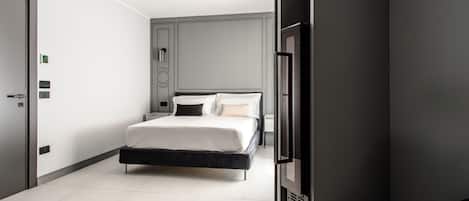 A modern bedroom with a bed, a wardrobe, and a built-in TV.