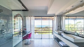 Un bagno moderno con box doccia in vetro, un lavandino capiente e vista sull'esterno.