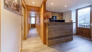 A modern kitchen with wooden cabinetry, a built-in microwave, and a large window offering a view of the outdoors.