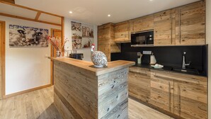 A modern kitchen with wooden cabinetry, a central island, and a microwave above the counter.