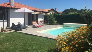 A house with a swimming pool, outdoor furniture, and a garden. - Maison Confort 3 Chambres Piscine- 6 Couchages, Tarnos Limite Pays Basques (Tarnos)