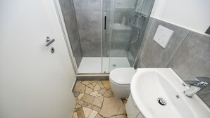 Un baño con ducha, inodoro y lavamanos.