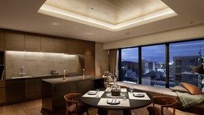 A modern kitchen with a dining area, large windows with a city view, and a built-in bench with cushions. - HIDEOUT (Kyoto)