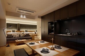 A modern hotel room with a bed, sofa, dining table, and kitchen area. - HIDEOUT (Kyoto)