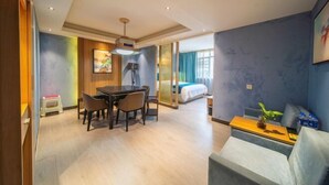 A hotel room with a dining area, a sofa, a bed, and a large window. - Jilong Hotel (Changsha County)