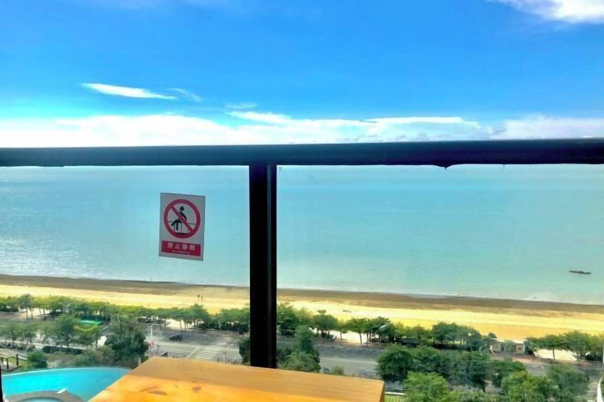 A view from a balcony overlooking a beach with a no swimming sign.