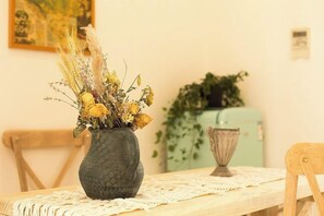 Una mesa con un jarrón de flores secas y un cuenco decorativo.