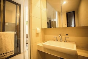 Une salle de bain équipée d’un lavabo, d’un miroir et d’un porte-serviettes.