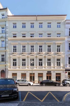 A multi-story building with a classical architectural style, featuring symmetrical windows and decorative moldings.