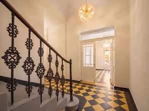 A staircase with ornate metal railings and a checkered floor pattern. - TurnKey | Republic Square Apartment V (Praha 1)