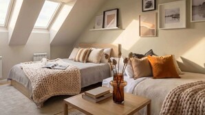 A bedroom with two beds, a skylight, and framed artwork on the wall. - TurnKey | Angelo Roma Cozy Studio  III (Praha 2)