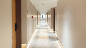 A long, narrow hotel corridor with a patterned carpet and light-colored walls. - JI Hotel (Zhoushan Daishan Branch) (Daishan)